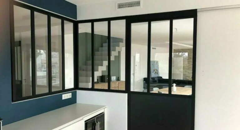 Verrière d’atelier noire séparant un palier et une cage d’escalier
