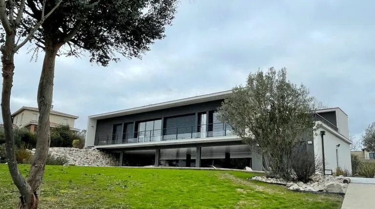 Maison contemporaine à toit plat et grandes baies, vue depuis le jardin